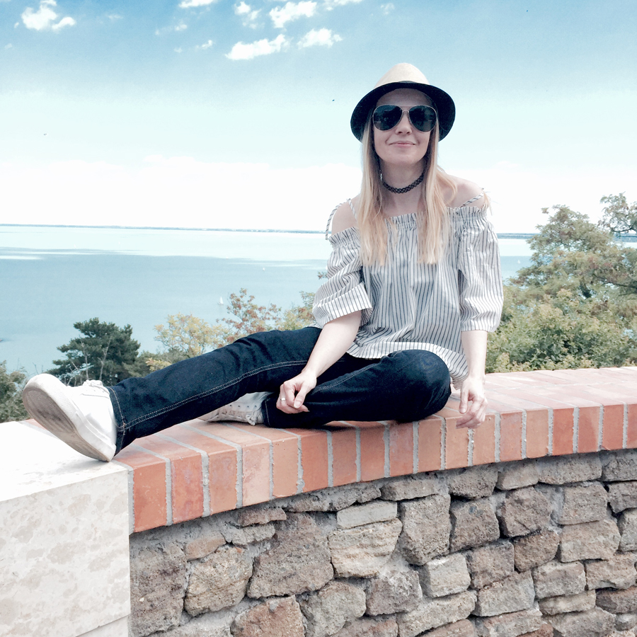 off-shoulder striped top, indigo slim straight jeans, white trainers, straw trilby, Nineties nylon choker, aviators, Lake Balaton view