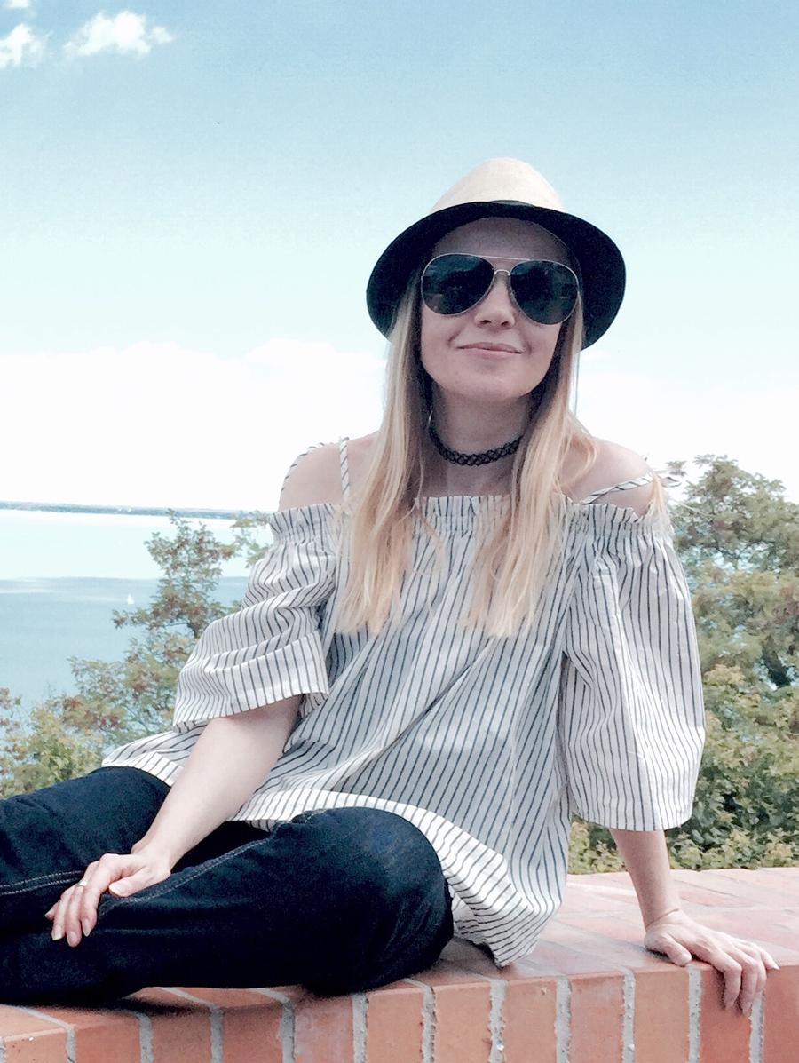 off-shoulder striped top, indigo slim straight jeans, white trainers, straw trilby, Nineties nylon choker, aviators