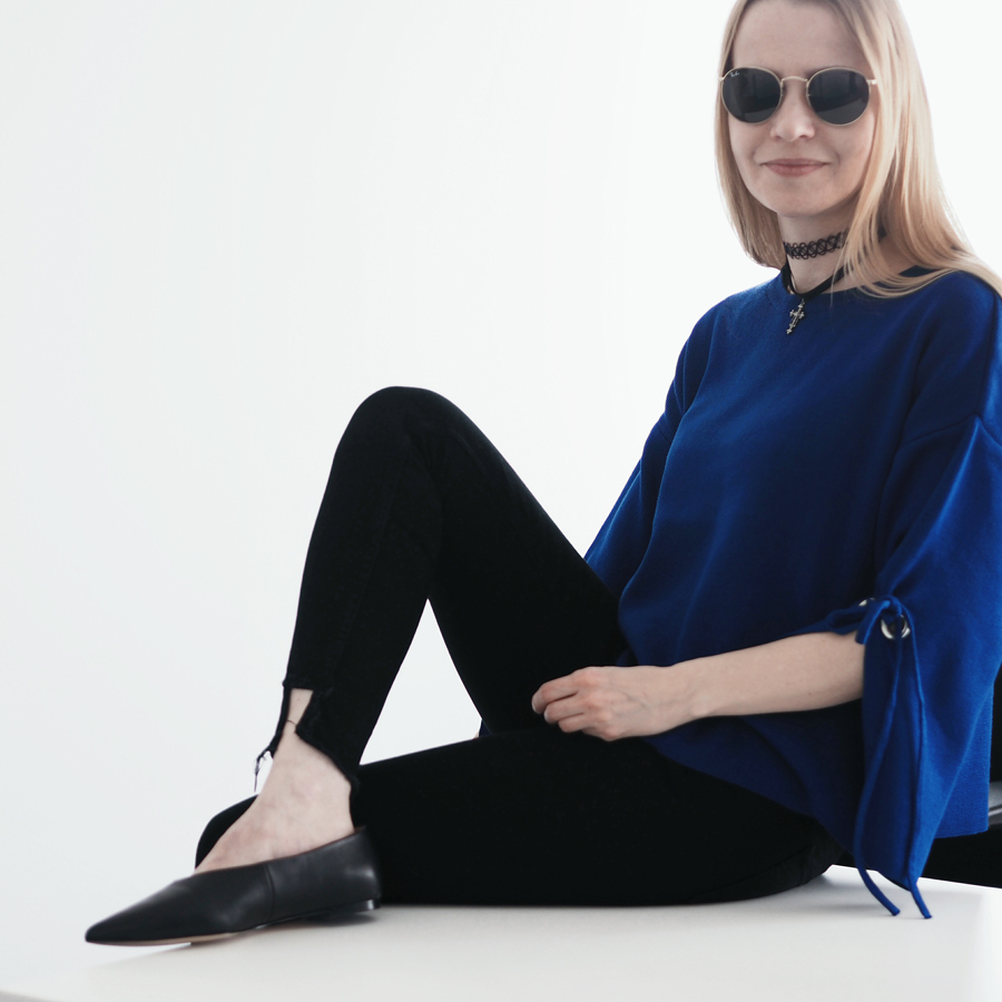 perfect effortless minimal cool workwear outfit look bold blue sleeve eyelet detail jumper raw hem black skinny jeans v-neck premium new season flats ray ban round sunglasses